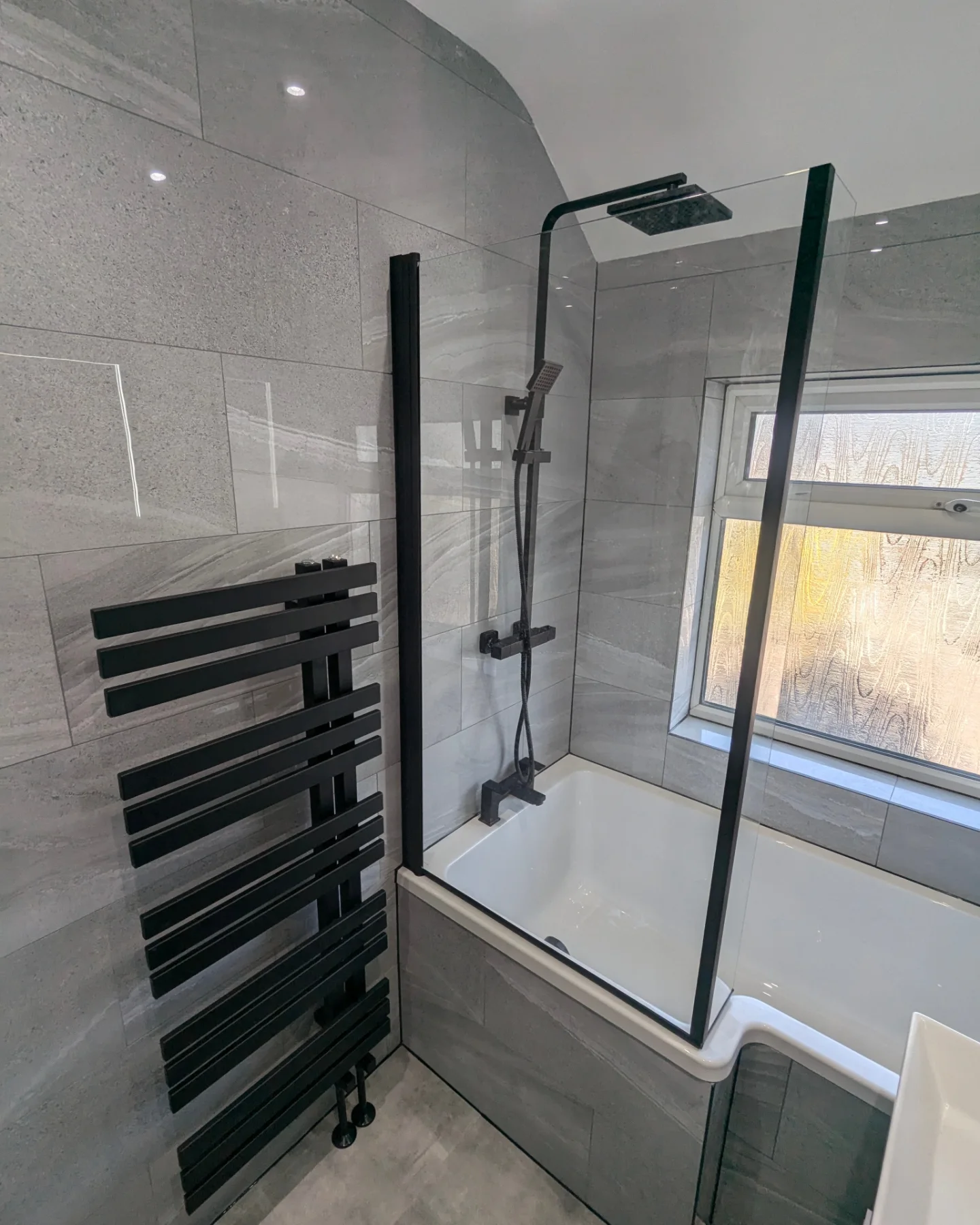 A bathroom with a bathtub and a radiator.